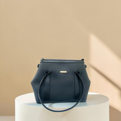 Graciza black faux leather Aero shoulder bag with flared wing design, gold bar hardware, and structured silhouette.