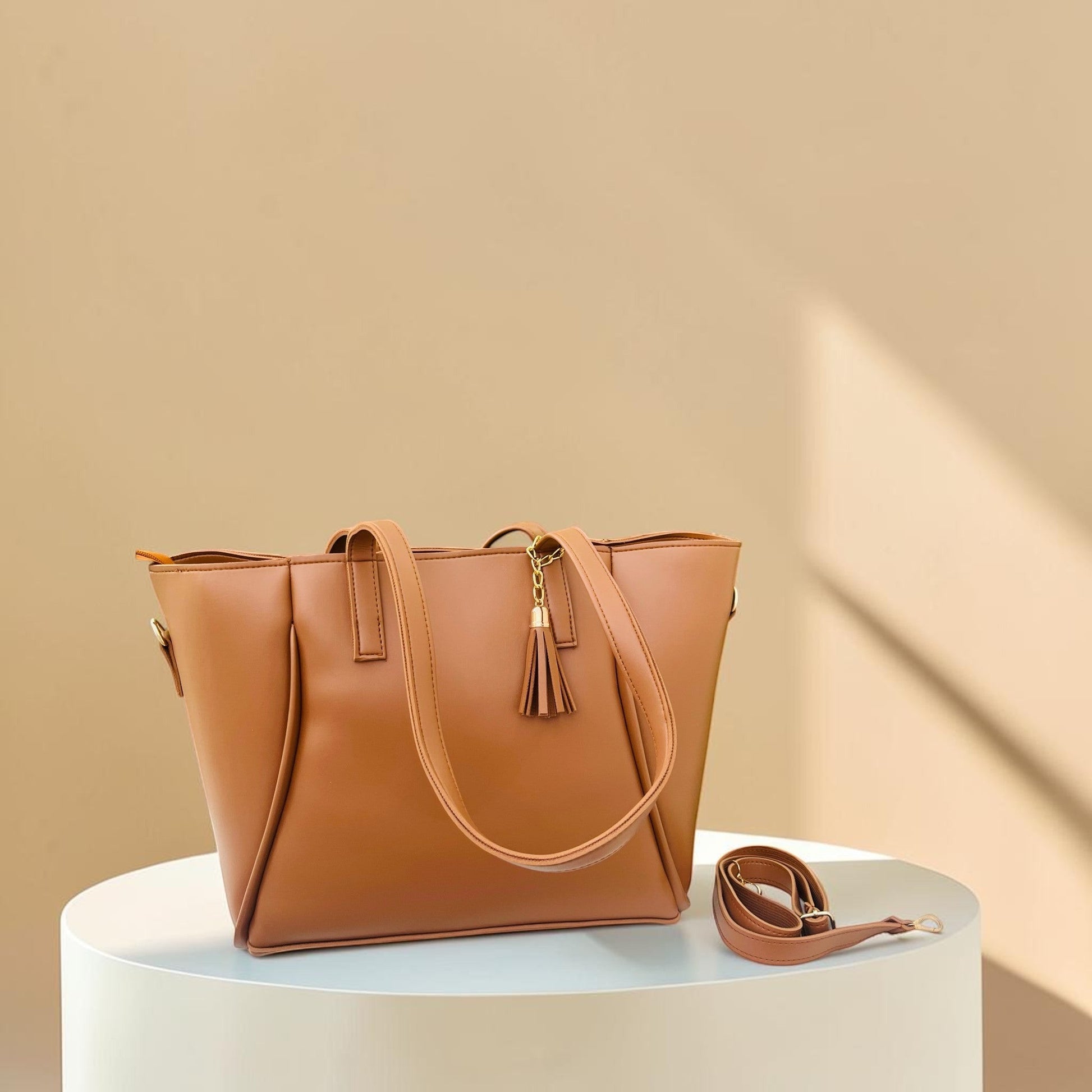 Graciza Aura brown faux leather tote bag with gold hardware, decorative tassel, and removable shoulder strap.