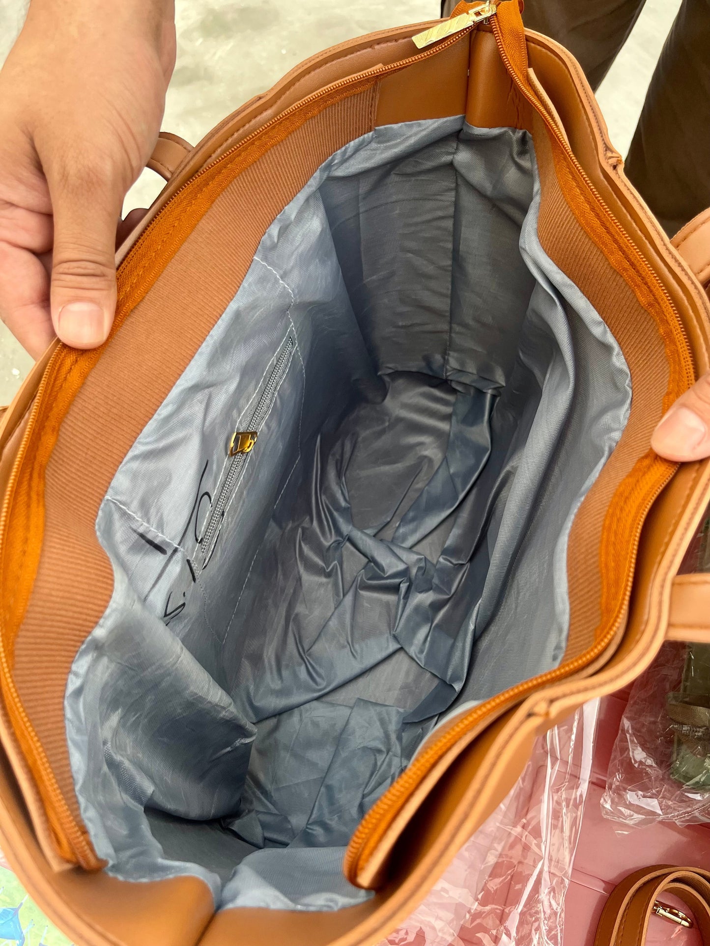Interior view of Graciza Aura brown faux leather tote bag with grey lining, zipper closure, and gold hardware.