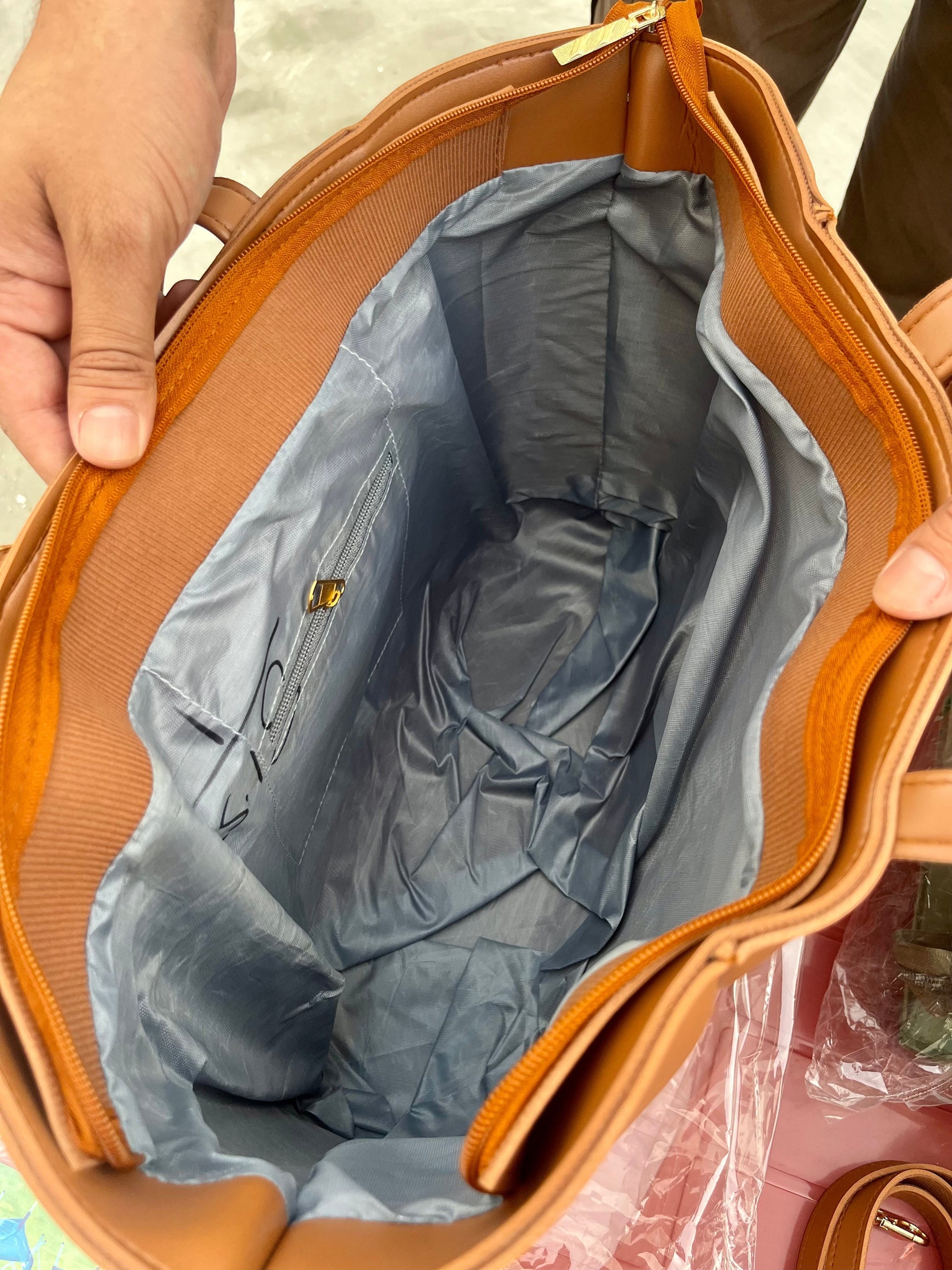 Interior view of Graciza Aura brown faux leather tote bag with grey lining, zipper closure, and gold hardware.