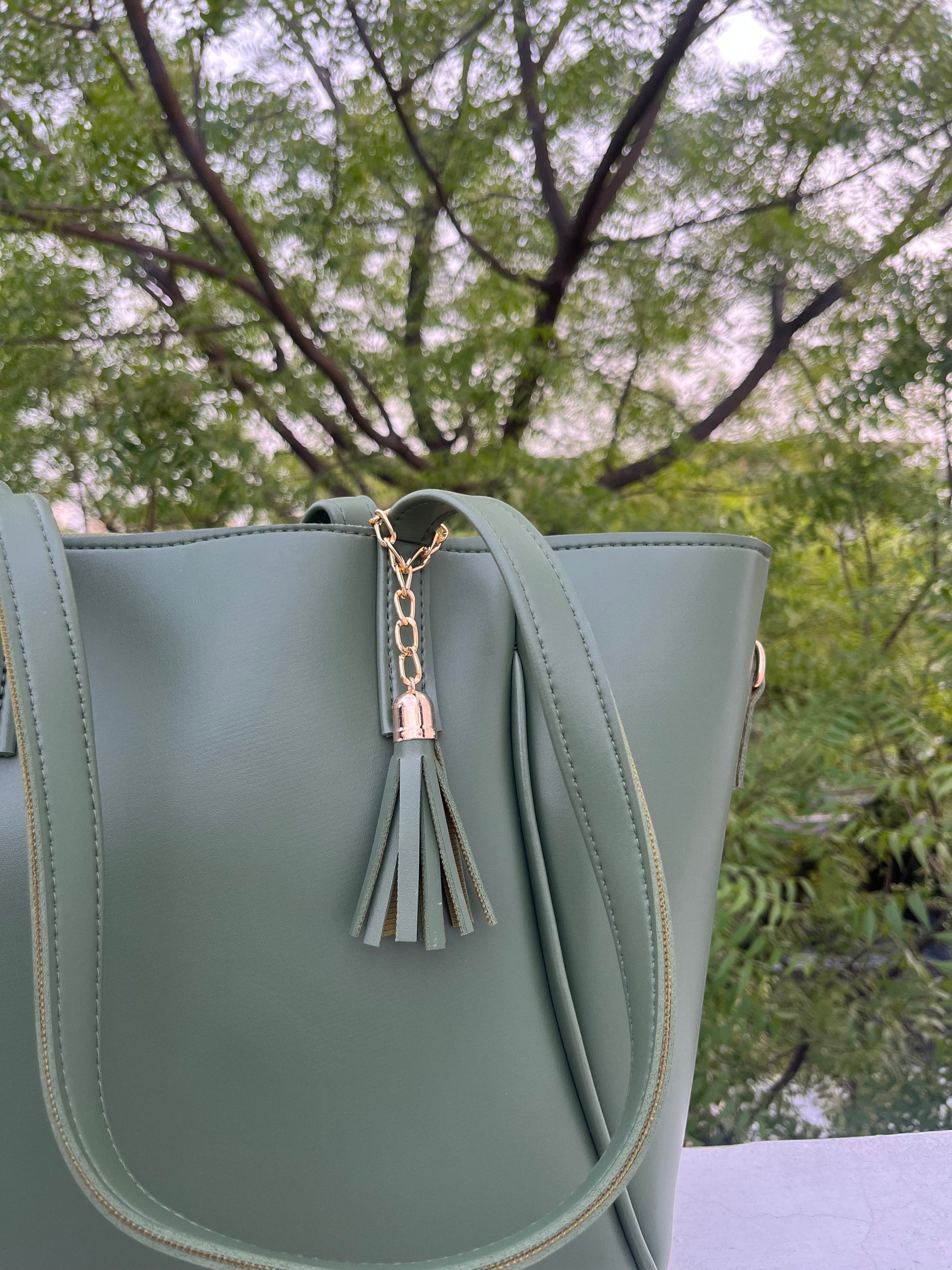 Graciza Aura green faux leather tote bag with gold-tone hardware and a decorative tassel detail.