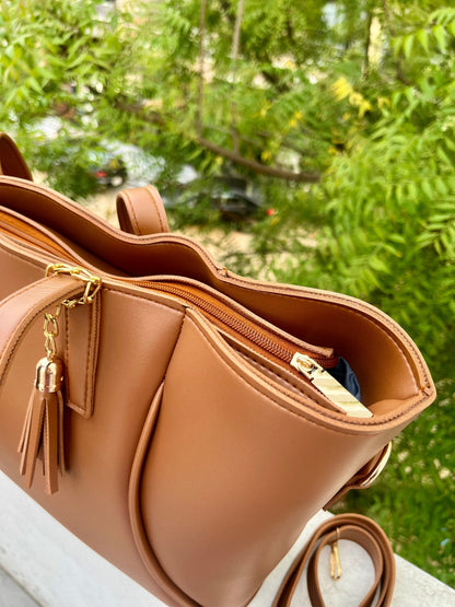 Graciza brown faux leather Aura Tote with gold-tone hardware, zipper closure, and decorative tassel detail.