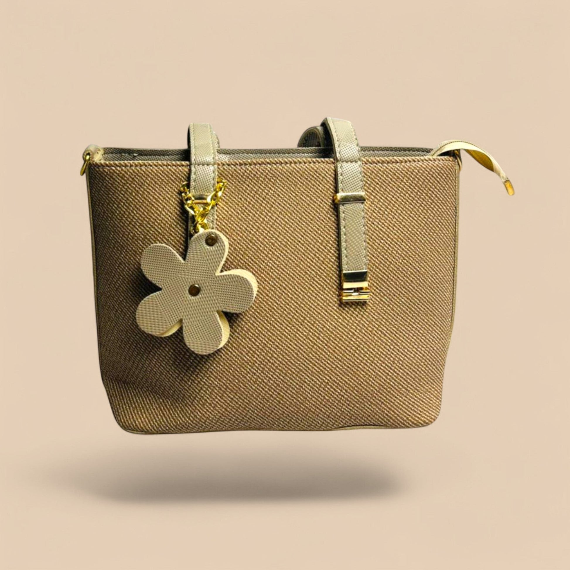 Graciza beige faux leather handbag with twin handles and a decorative floral charm for a stylish everyday look.
