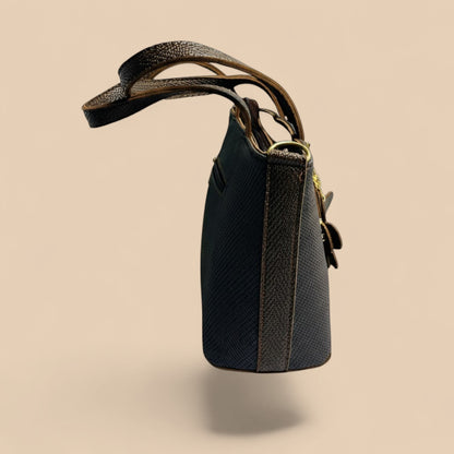 Graciza Bloom brown faux leather handbag with floral charm, adjustable strap, and twin handles on a neutral background.