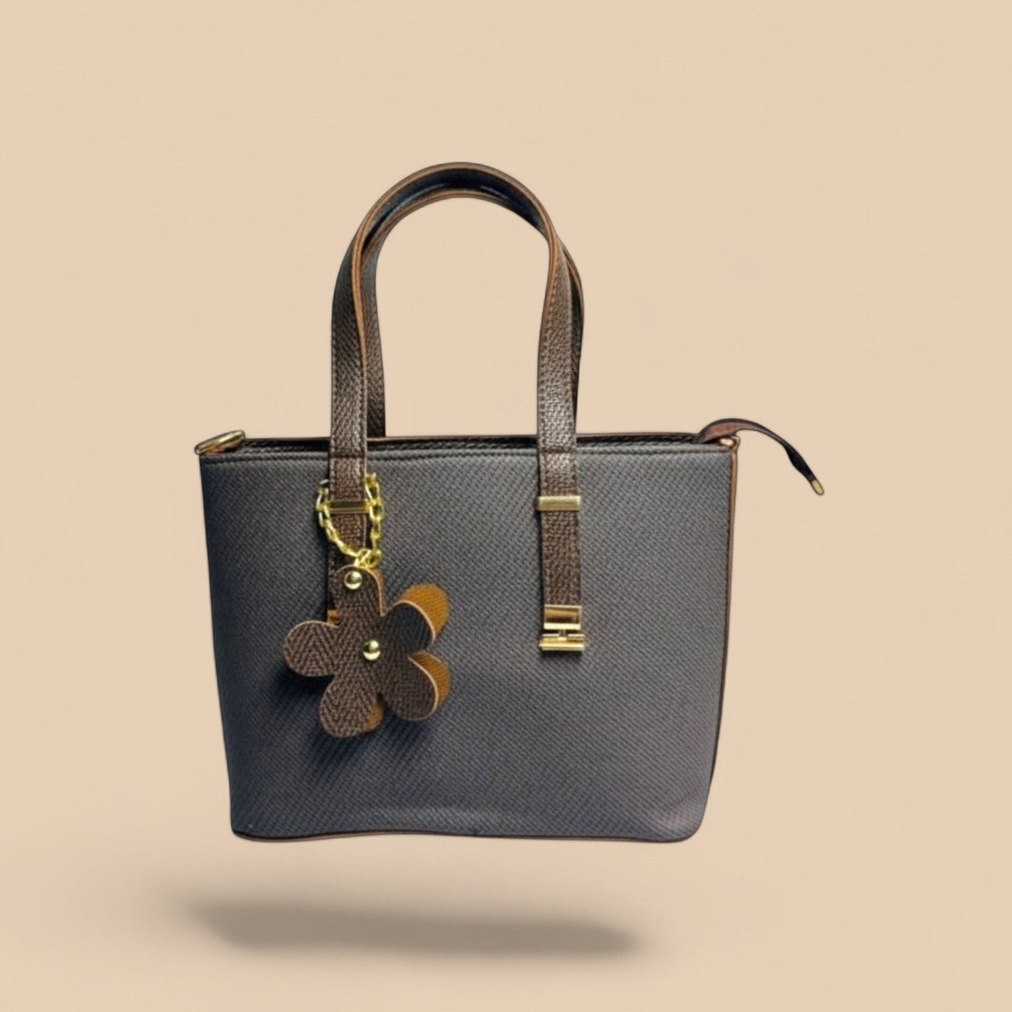 Graciza brown faux leather Bloom handbag with twin handles, zip closure, and a decorative floral charm.