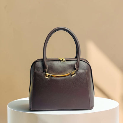Graciza Elara structured handbag in chocolate brown faux leather with polished gold hardware and twin handles.