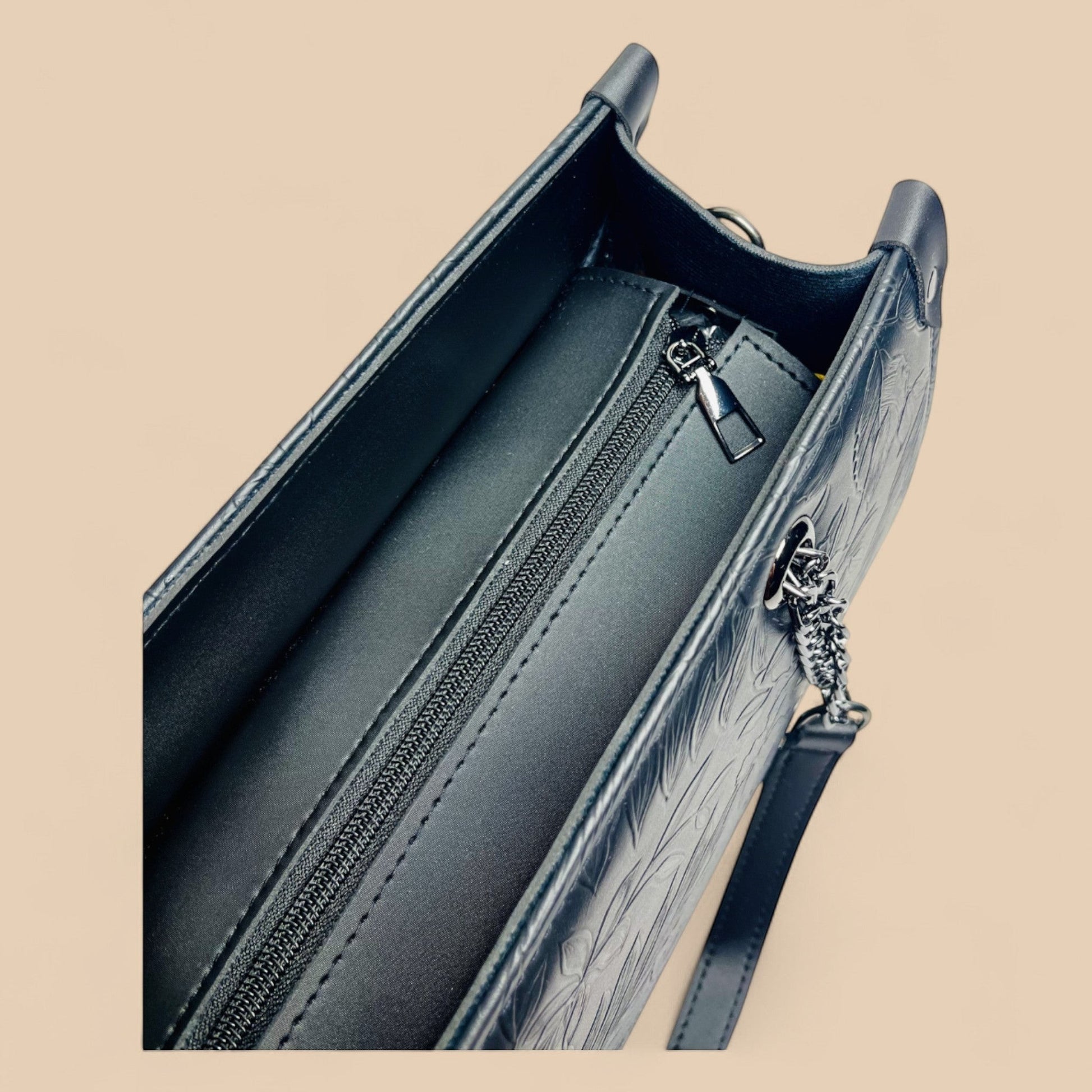 Graciza Flora black faux leather shoulder bag with top-zip closure, textured floral pattern, and silver chain detail.