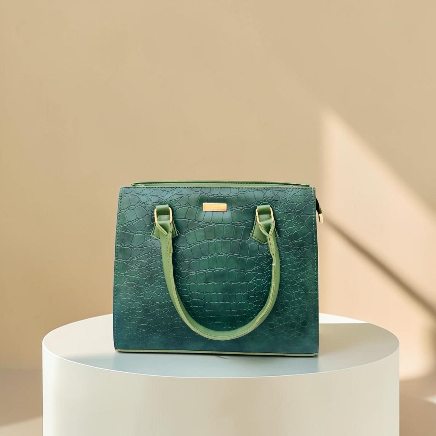 Graciza Lyra green faux leather handbag with crocodile texture and gold hardware on a white pedestal