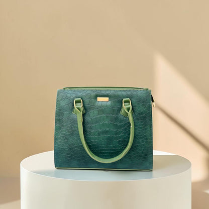 Graciza Lyra green faux leather handbag with crocodile texture and gold hardware on a white pedestal