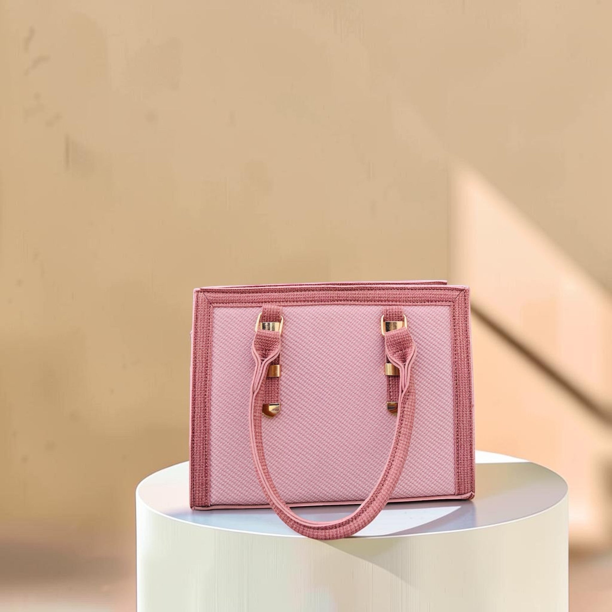 Graciza Sia square faux leather handbag in two-tone pink with textured panels and minimalist handles.