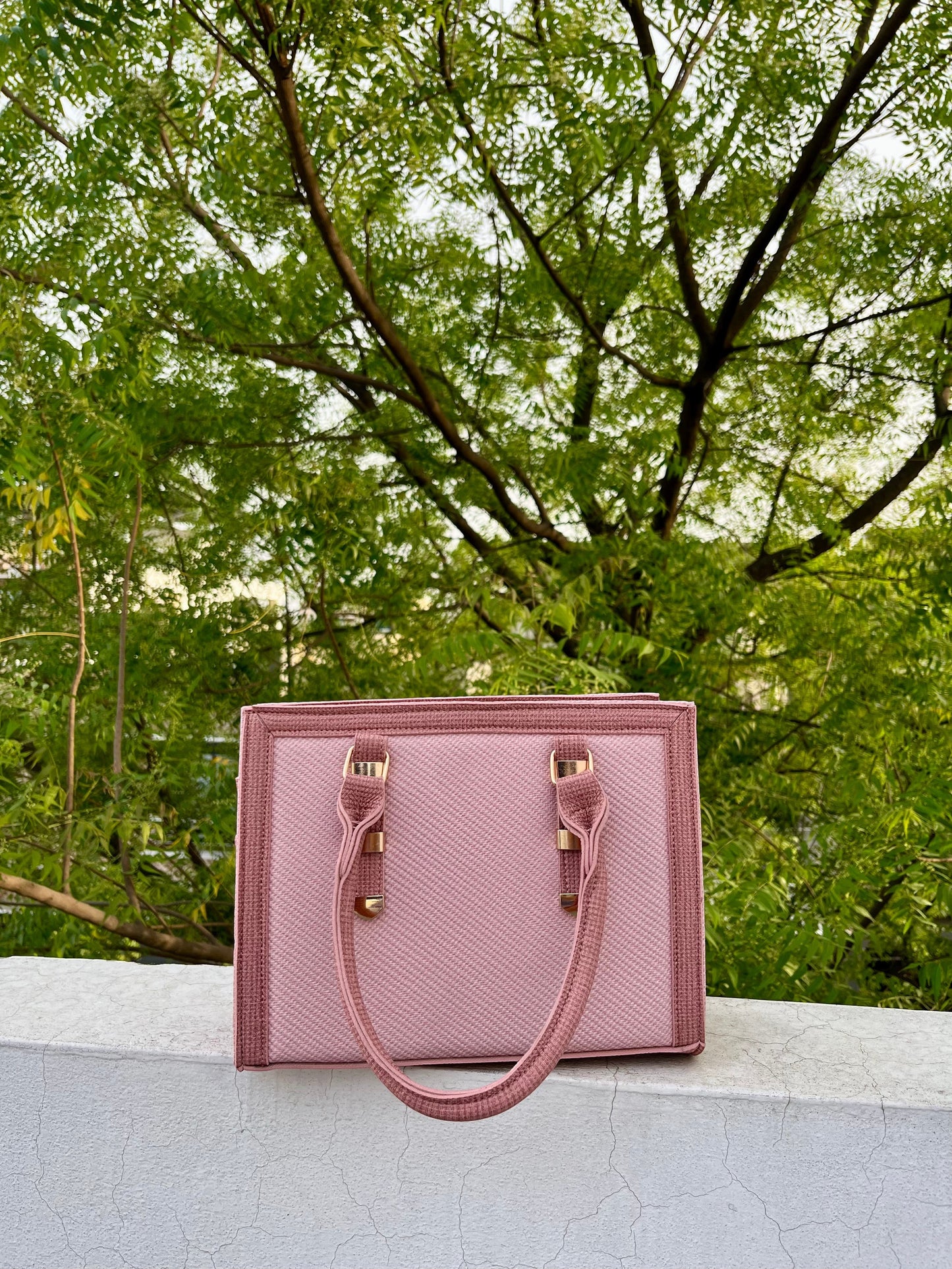 Graciza Sia pink faux leather square tote handbag with textured panels and double handles outdoors.