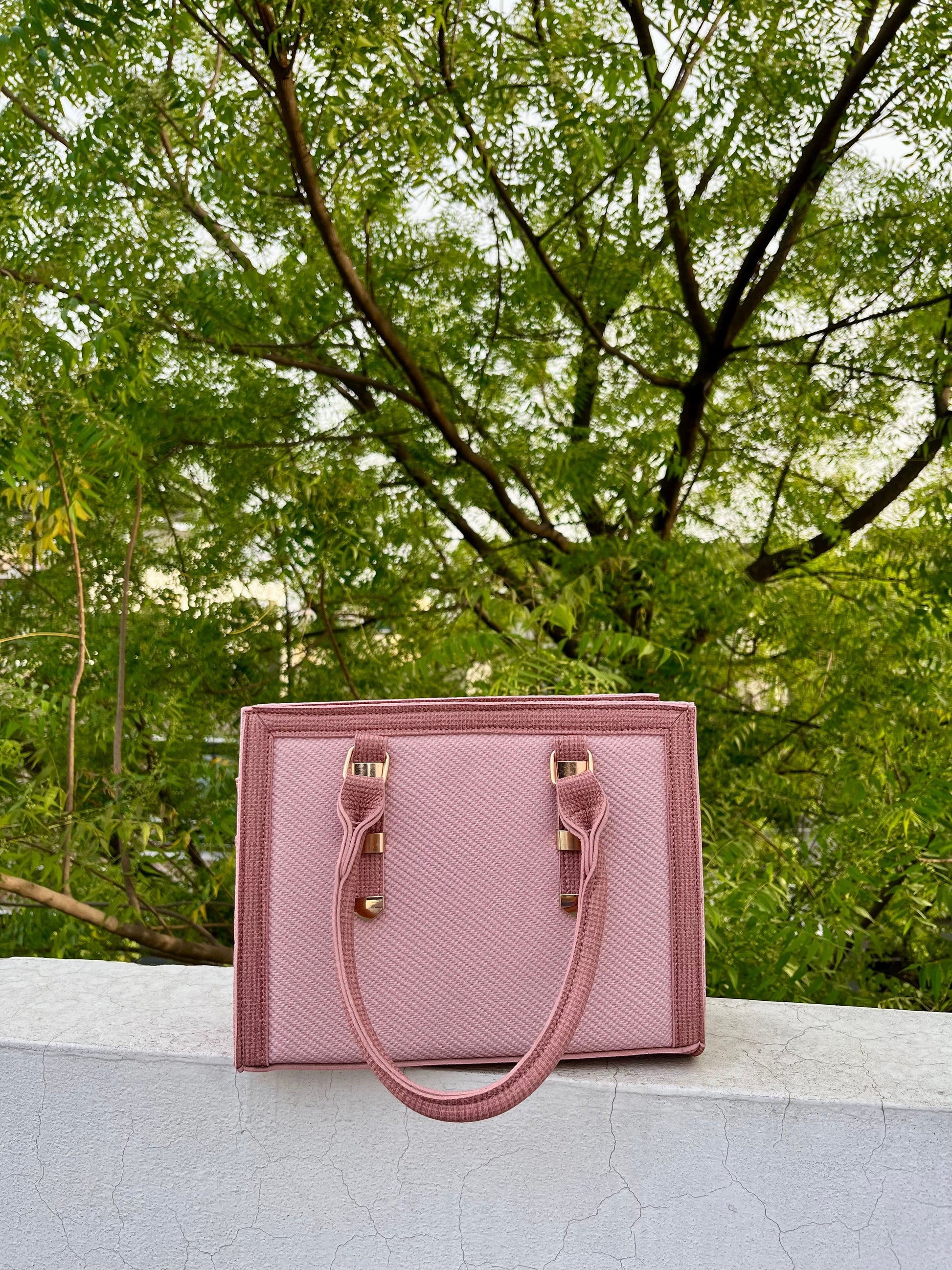 Graciza Sia pink faux leather square tote handbag with textured panels and double handles outdoors.