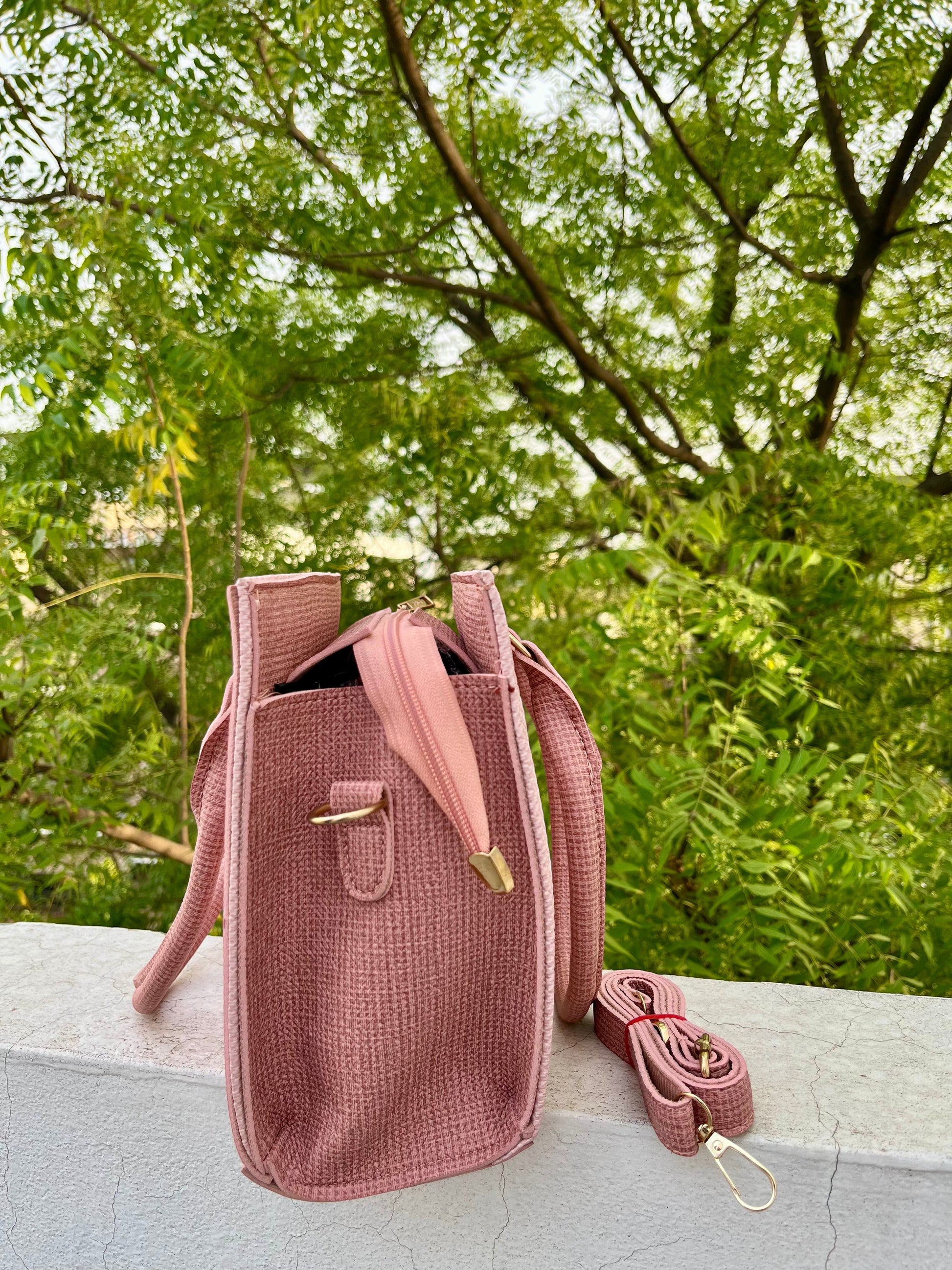 Graciza Sia pink faux leather square handbag with textured panels and detachable shoulder strap outdoors.